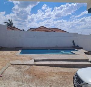 a swimming pool in the backyard of a house at Aquamarine Guesthouse in Morula Sun