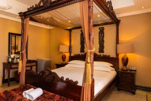 a bedroom with a four poster canopy bed at Premier Hotel Anta Boga in Bloemfontein +39 photos