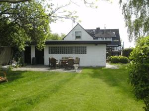 ein weißes Haus mit einem Tisch und Stühlen im Hof in der Unterkunft Ferienhaus am Fuchsberg in Dahme