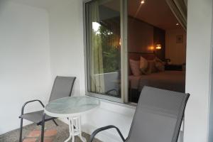 a room with a table and chairs and a bed at Residy Hideaway in Patong Beach