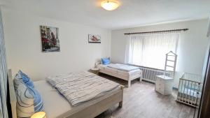a bedroom with a bed and a crib in it at Nordsee Ferienwohnung Süd in Dornumersiel