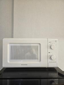 a white microwave oven sitting on top of a stove at STAY Humming in Seoul