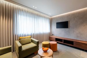 a hotel room with a chair and a television at Selemnos Boutique in Patra