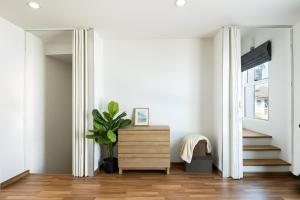 a living room with stairs and a dresser and a mirror at Spacious 3BR BKK NEAR 3 Private Bathrooms FAMILY STAY in Min Buri