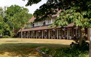 a large building with a large yard in front of it at Landhuishotel De Bloemenbeek in De Lutte