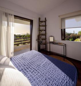 a bedroom with a bed and a large window at Cyan Villa in Anavyssos +16 photos