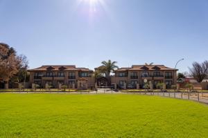 a large grassy field in front of a building at Premier Hotel Anta Boga in Bloemfontein