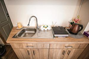 a kitchen counter with a sink and a laptop on it at Central garsoniera ap 3 in Târgu-Mureş +4 photos