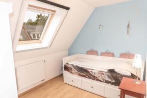 a bedroom with a bed in a room with a window at Ferienhaus Kranich in Pruchten