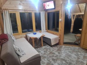 a living room with a couch and a table at Markove kolibe 6, Uvac in Sjenica