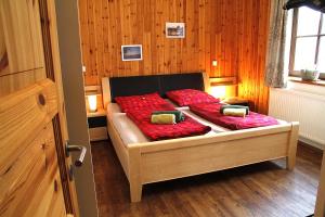 a bedroom with a bed with red pillows at Eifelhof Bock in Hürtgenwald