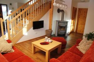 a living room with a couch and a table and a fireplace at Eifelhof Bock in Hürtgenwald