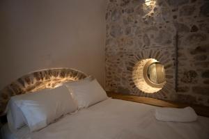 a bedroom with a bed with a stone wall at Yermata Kalamoti in Kalamoti