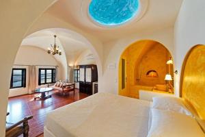 a bedroom with a large bed and a living room at Lava On the Cliff in Fira +92 photos