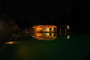 a house at night with a swimming pool at Seaclusion Diani in Diani Beach