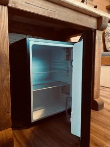 an empty refrigerator with its door open in a kitchen at Tiny House Jovana in Kröpelin +9 photos