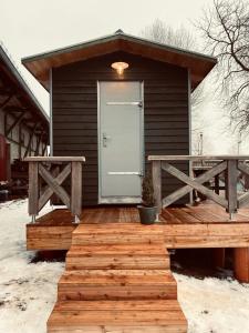 a house with a wooden deck with a door at Tiny House Jovana in Kröpelin