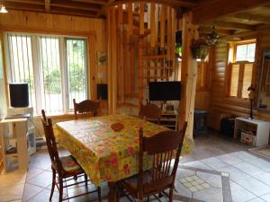 a dining room with a table and chairs in a cabin at Chalet Saint-Thomas in LʼAnse-Saint-Jean