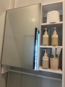a bathroom cabinet with two bottles of soap and towels at Lunara Homestay in Phú Vang
