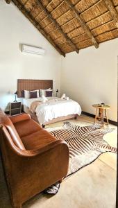 ein Schlafzimmer mit einem Bett, einem Stuhl und einem Teppich in der Unterkunft Kitchen51 Cottages in Keetmanshoop
