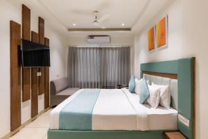 a hotel room with a bed and a television at FabHotel Prime The Oasis in Bhopal