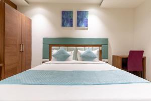 a bedroom with a large white bed with blue sheets at FabHotel Prime The Oasis in Bhopal +45 photos