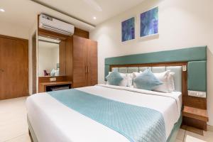 a bedroom with a large bed with blue and white pillows at FabHotel Prime The Oasis in Bhopal