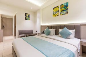 a hotel room with a large bed and a chair at FabHotel Prime The Oasis in Bhopal