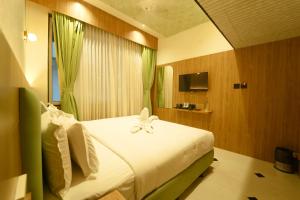 a bedroom with a bed with a flower on it at Yuvraj Land Mark in Mysore