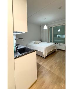 a kitchen with a sink and a bed in a room at LuxHOMES Studio in Tapiola in Espoo +5 photos