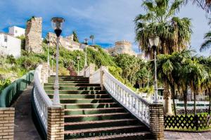 a staircase leading up to a castle with palm trees at Casa de los hermanos in Almuñécar