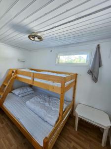 a bunk bed in a small room with a window at Strandbacka Stugor in Gnisvärd +41 photos