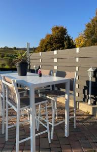 a white table and chairs on a patio at B&B Chalet Grillkota in Trasadingen