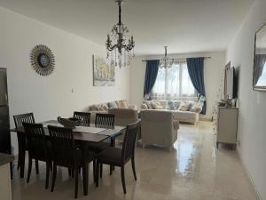 a dining room and living room with a table and chairs at Dream Apartment in Salalah