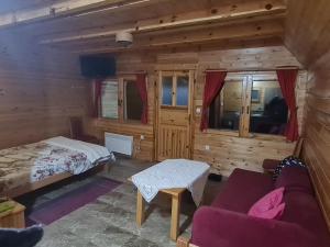 a bedroom with a bed and a couch in a room at Markove kolibe 4, Uvac in Sjenica