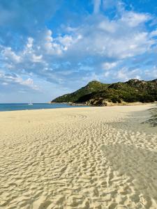 a sandy beach with a view of the ocean at Home Nicola Jago in Castiadas