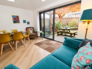 a living room with a blue couch and a table at Still Waters in Wyke Regis