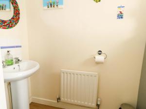 a bathroom with a sink and a white radiator at Still Waters in Wyke Regis +34 photos