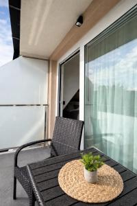 a patio table with a potted plant on a balcony at Giorgio Luxury Suites in Belgrade