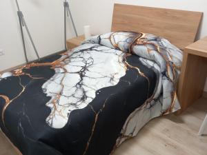 a bed with a black and white comforter at Meri per sempre in Pontebba