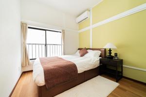a bedroom with a bed and a window at NISHIKI Ryokan錦旅館 in Tokyo