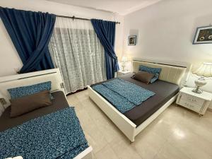 a bedroom with two beds and a window at Dream Apartment in Salalah