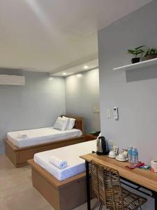 a room with two beds and a table with a table at ALESSANDRA HOTEL in Calaca