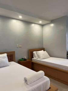a bedroom with two beds with white sheets at ALESSANDRA HOTEL in Calaca