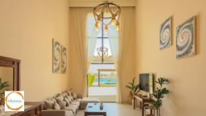 a living room with a couch and a chandelier at Heated Pool 4BR Villa, Lagoon Front, Ancient Sands - OllyStays in El Gouna
