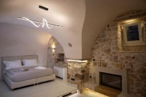 a bedroom with a bed and a stone wall at Yermata Kalamoti in Kalamoti