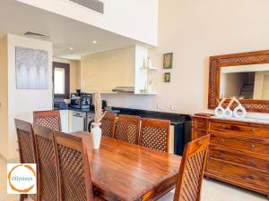 a kitchen and dining room with a wooden table and chairs at Heated Pool 4BR Villa, Lagoon Front, Ancient Sands - OllyStays in El Gouna