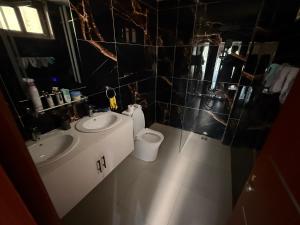 a bathroom with two sinks and a toilet in it at Sylla in Dakar