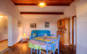 a dining room with a table and blue chairs at Casa Lisandru in Croce