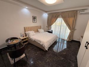 a bedroom with a bed and a table and a window at Sylla in Dakar